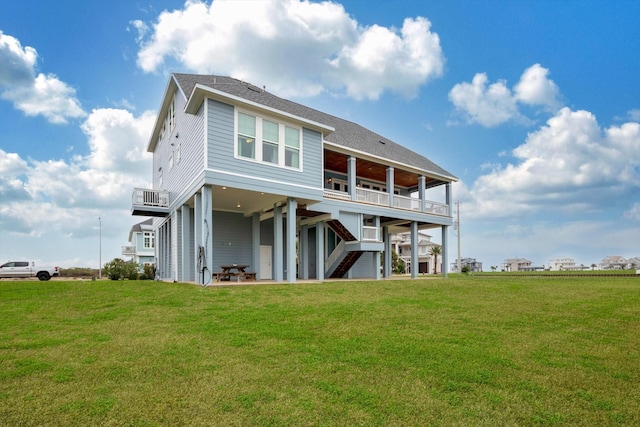 rear view of property featuring a lawn and a balcony