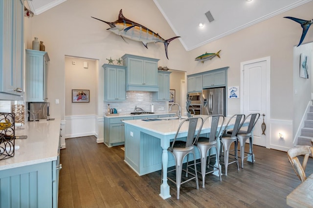 kitchen featuring ornamental molding, appliances with stainless steel finishes, a kitchen breakfast bar, and a kitchen island