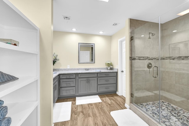 bathroom with a shower with door, vanity, and hardwood / wood-style floors