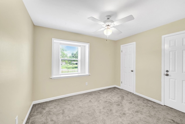 empty room featuring light colored carpet and ceiling fan