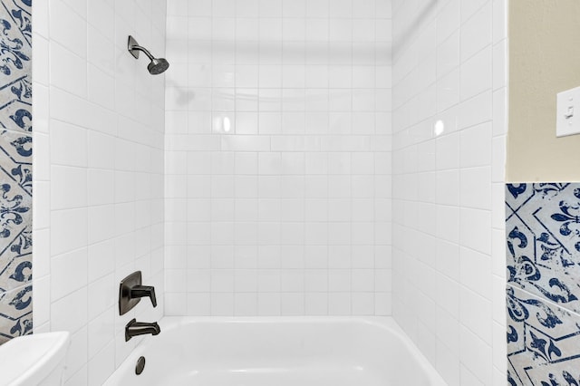 bathroom featuring tiled shower / bath and toilet