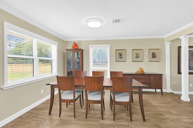 dining room with light hardwood / wood-style flooring, ornamental molding, and ornate columns