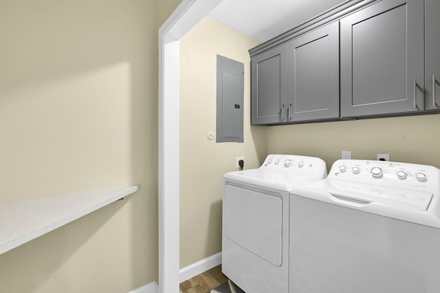 washroom with cabinets, washing machine and clothes dryer, electric panel, and dark wood-type flooring