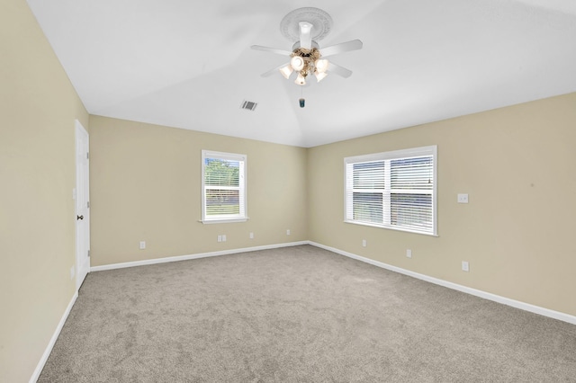 empty room featuring ceiling fan, lofted ceiling, and light carpet