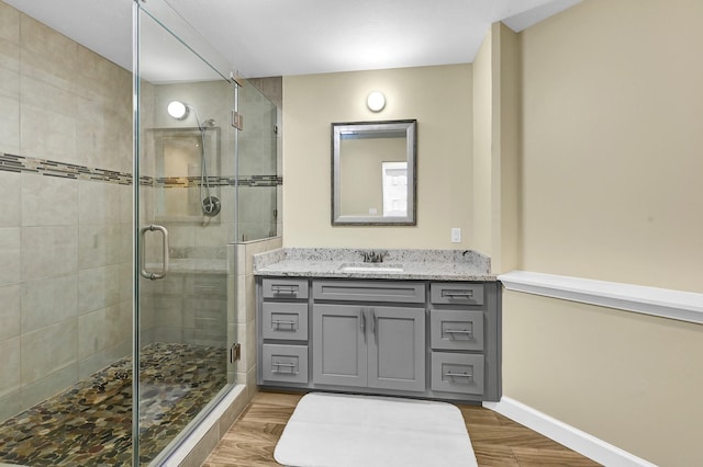 bathroom featuring a shower with door, vanity, and hardwood / wood-style flooring