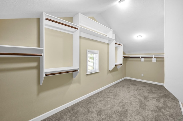 walk in closet featuring light colored carpet and lofted ceiling