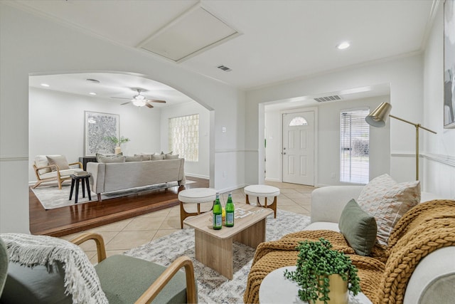 tiled living room featuring ornamental molding and ceiling fan