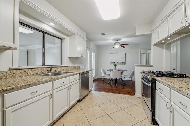 kitchen with stainless steel appliances, white cabinetry, sink, and light tile patterned floors