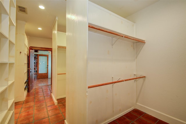 walk in closet with dark tile patterned flooring