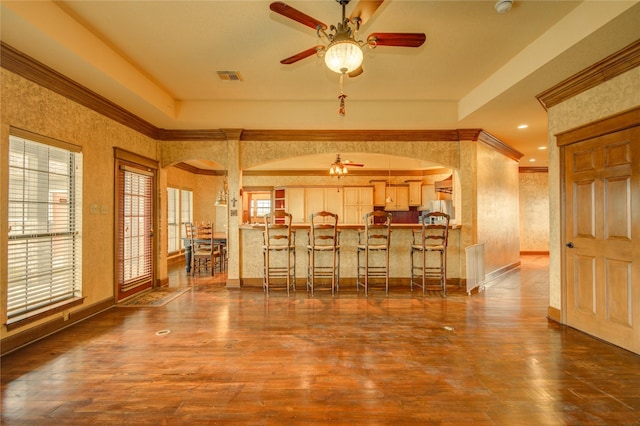 dining space with dark hardwood / wood-style flooring, crown molding, and ceiling fan