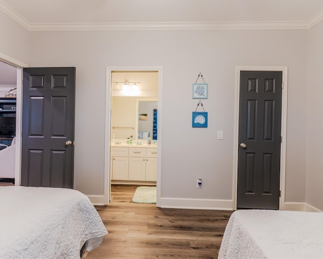 bedroom with ornamental molding, hardwood / wood-style floors, and ensuite bathroom