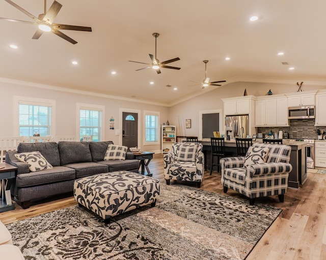 living room featuring vaulted ceiling, ornamental molding, and plenty of natural light