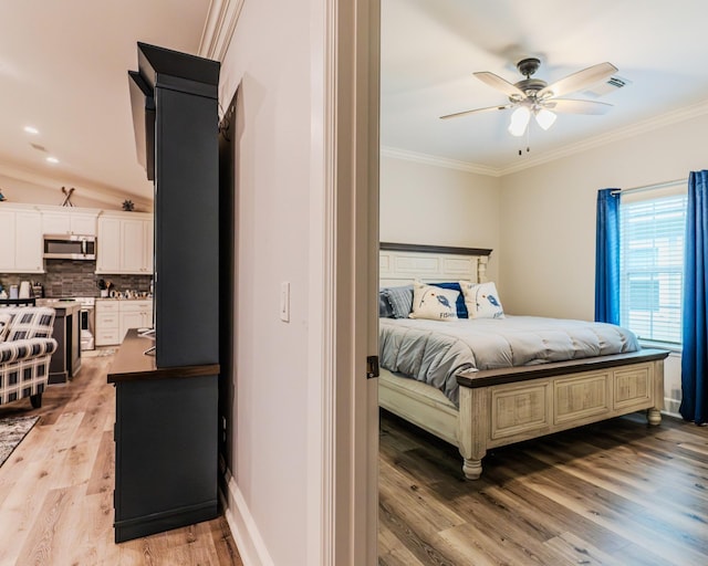 bedroom with crown molding, light hardwood / wood-style floors, and ceiling fan