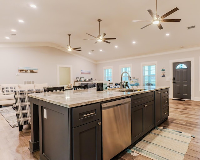 kitchen featuring lofted ceiling, sink, a kitchen island with sink, light stone countertops, and stainless steel dishwasher