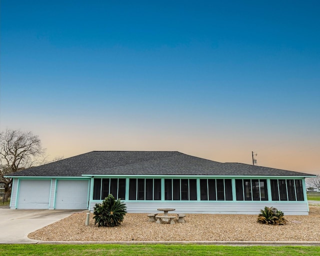 back house at dusk featuring a garage