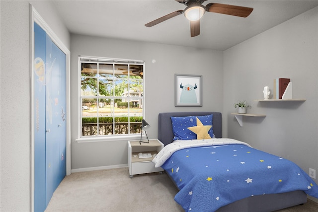 carpeted bedroom with ceiling fan and a closet