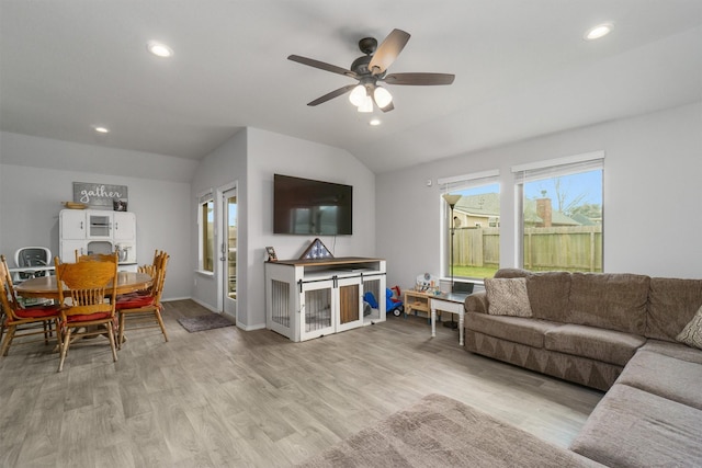 living room with lofted ceiling, ceiling fan, and light hardwood / wood-style flooring