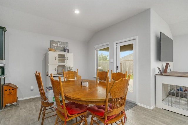 dining area with vaulted ceiling and light hardwood / wood-style floors