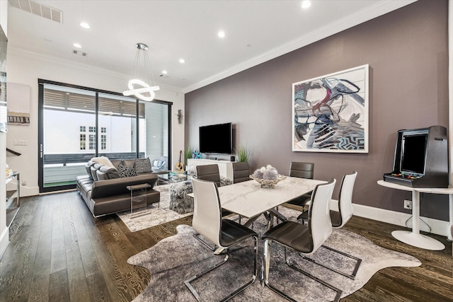 dining area featuring baseboards, ornamental molding, a chandelier, and dark wood-style flooring