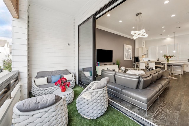 living room featuring dark wood-style floors, ornamental molding, a chandelier, and recessed lighting