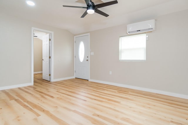 entryway featuring a wall mounted air conditioner, ceiling fan, and light hardwood / wood-style flooring