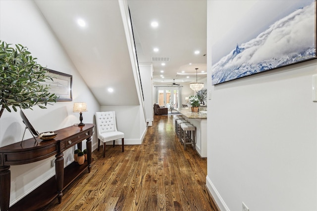 corridor with lofted ceiling and dark hardwood / wood-style floors