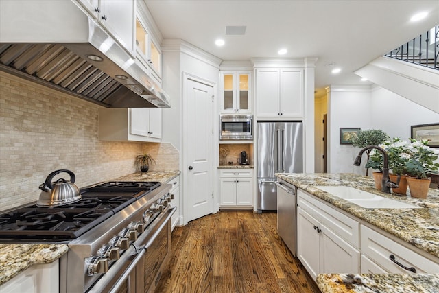 kitchen with white cabinetry, premium appliances, sink, and extractor fan