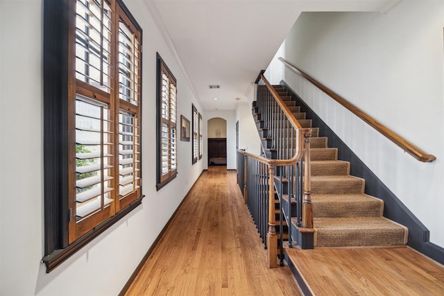 hallway with hardwood / wood-style flooring and ornamental molding