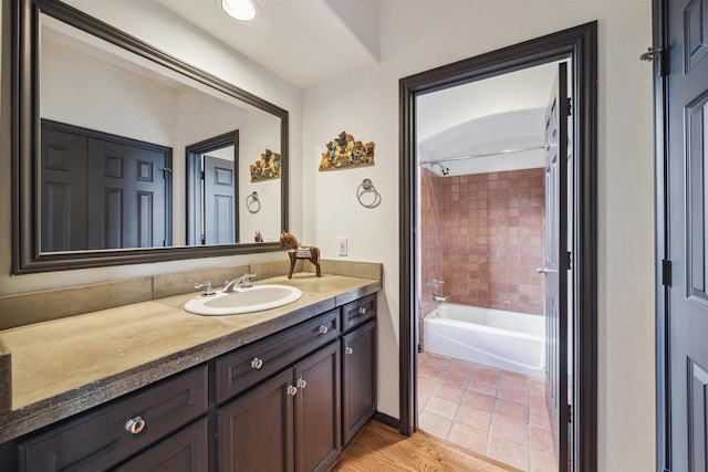 bathroom featuring vanity, tile patterned flooring, and tiled shower / bath