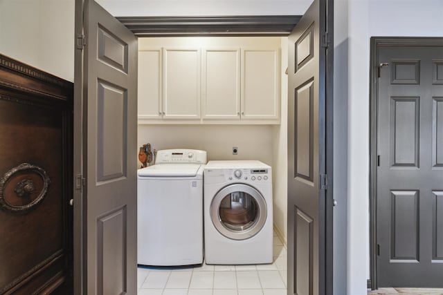 laundry room featuring cabinets, washer and dryer, and light tile patterned flooring