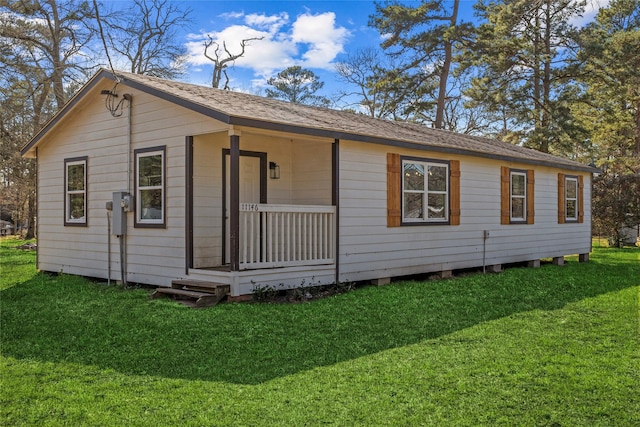 view of front of property featuring a shingled roof and a front lawn