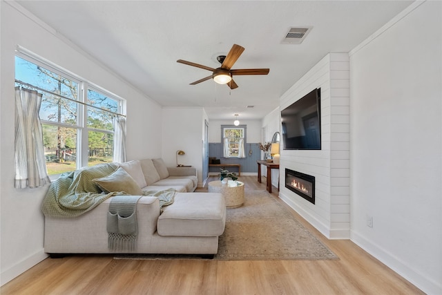 living area featuring a wealth of natural light, wood finished floors, and visible vents