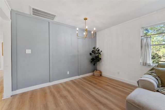 sitting room with baseboards, visible vents, light wood finished floors, and an inviting chandelier