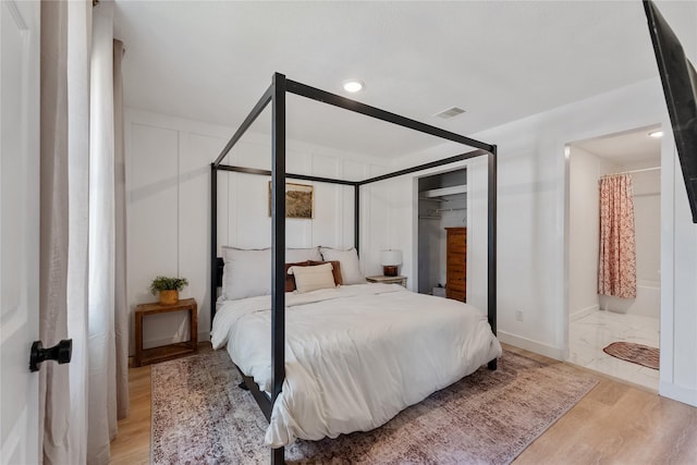 bedroom featuring light wood-style flooring, a closet, visible vents, and baseboards