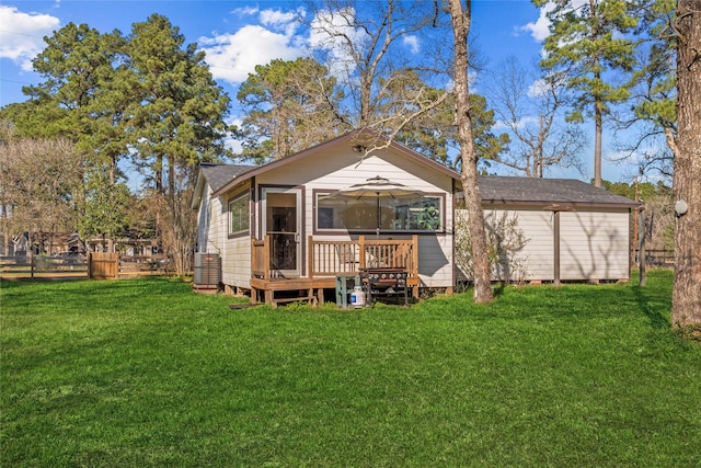 rear view of house featuring a deck, a lawn, and fence