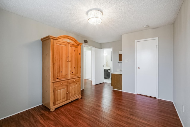 spare room featuring dark hardwood / wood-style floors and a textured ceiling