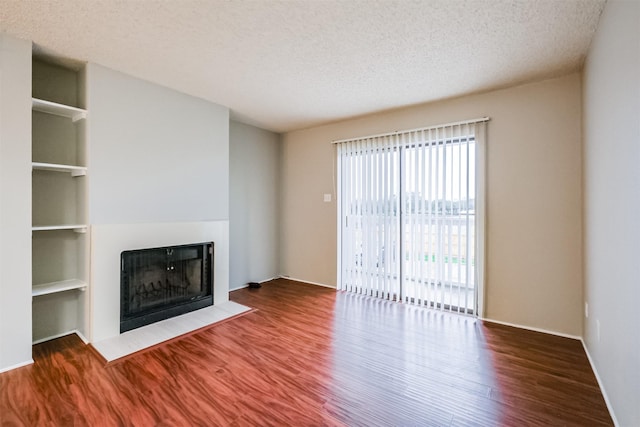 unfurnished living room with hardwood / wood-style flooring and a textured ceiling