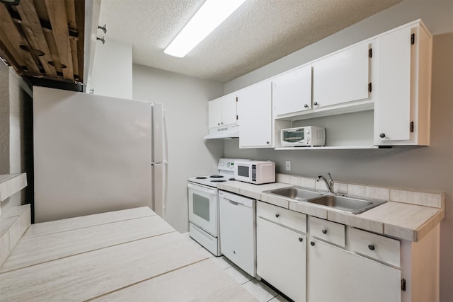 kitchen featuring white cabinetry, sink, a textured ceiling, and white appliances