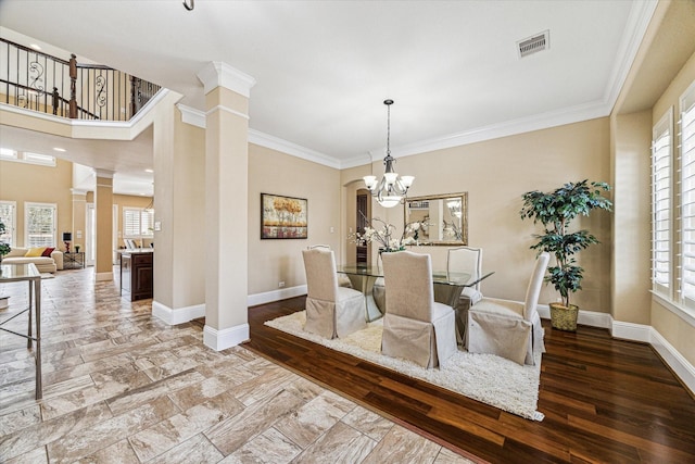 dining area featuring ornate columns, hardwood / wood-style flooring, and a wealth of natural light