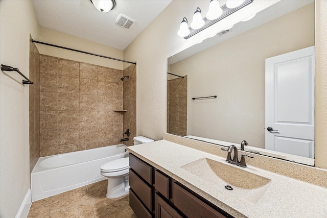 full bathroom with vanity, tiled shower / bath combo, and toilet