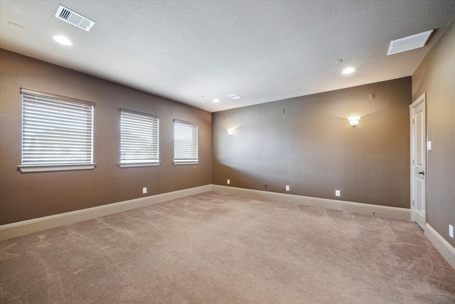 unfurnished room with light carpet and a textured ceiling