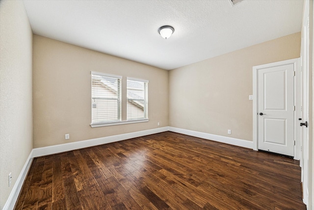 unfurnished room with dark wood-type flooring