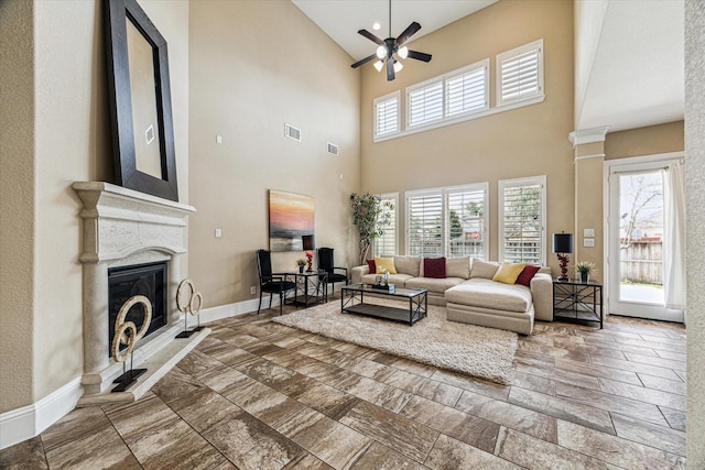 living room featuring a premium fireplace and ceiling fan