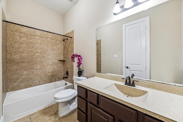 full bathroom featuring tiled shower / bath, vanity, and toilet