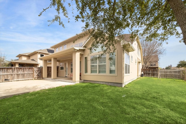 rear view of house featuring a patio and a lawn