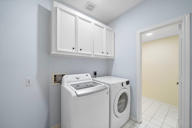 washroom featuring cabinets, light tile patterned flooring, and washer and clothes dryer