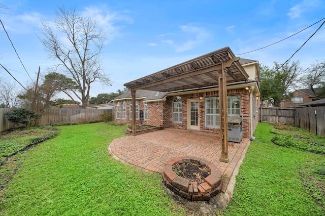 back of house with a pergola, a fire pit, a patio, and a lawn