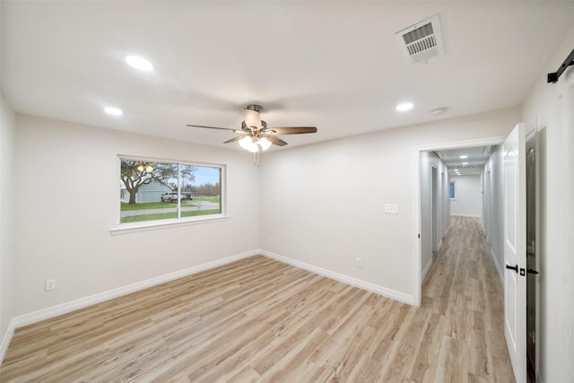 spare room with ceiling fan and light wood-type flooring