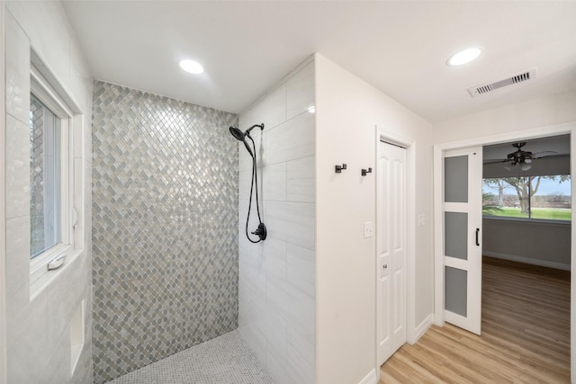 bathroom featuring hardwood / wood-style flooring and tiled shower