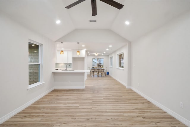 interior space with lofted ceiling, sink, light hardwood / wood-style flooring, and ceiling fan